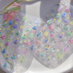 Detail of Christmas nail art stickers with 3D glitter trees and white snowflakes