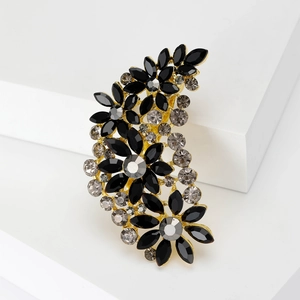 Detail of vintage flower brooch with black and grey crystals on gold metal base