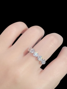 Close-up of S925 sterling silver heart-shaped eternity ring worn on a finger
