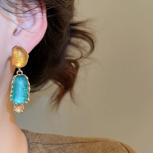 Detailansicht der Vintage-Resin-Ohrringe mit bernstein- und grünen Steinen in Gold