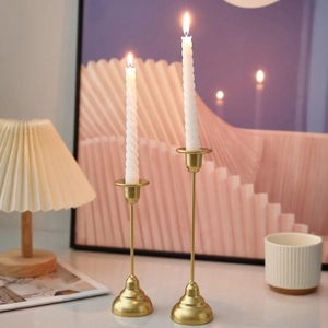 Set of two gold metal candle holders with white spiral candles for romantic dining decor