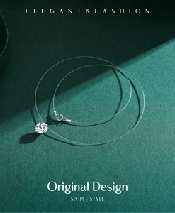Vue macro d'un pendentif en argent et zircone sur un fil invisible de style minimaliste