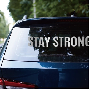 Waterproof vinyl sticker with Stay Strong lettering on a dark blue car window