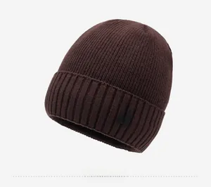 Detail of dark brown knitted beanie featuring a black woven label with NY&JA logo text