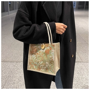 Detail of floral tapestry linen tote bag with woven rope handles and a wooden button