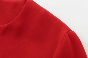 Macro shot of red crepe fabric texture with premium double-stitched seam details
