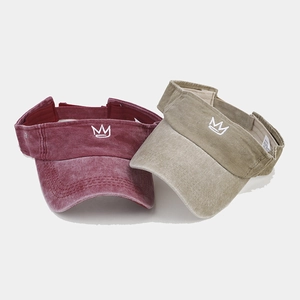 Detail of burgundy and khaki sun visors with white crown embroidery and washed fabric
