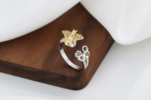 Detail of adjustable honeycomb ring featuring a gold bee and amber zircon accents
