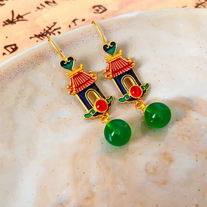 Macro shot of 18K gold heart earrings with traditional Chinese enamel and green bead detail