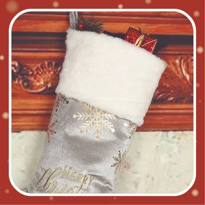 Detail of silver velvet Christmas stocking with gold snowflake patterns and white fur trim