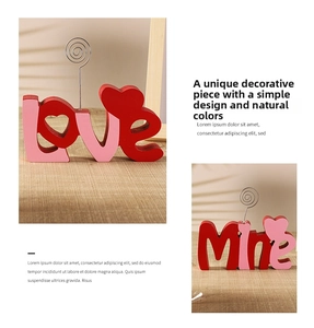Detail of red and pink wooden love letters with metal photo clips on wood surface
