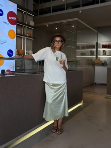 Close-up of a white cotton t-shirt with a coffee cup print and a satin midi skirt