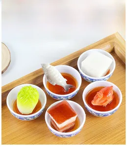 Detailed macro view of miniature food set with five ceramic bowls on a wooden tray