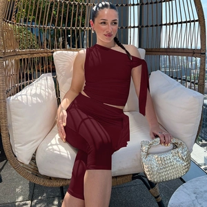 Detail of burgundy two-piece set featuring a one-shoulder top and high waist pants