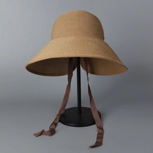 Detail of the woven texture and inner brown ribbon tie on a sun straw hat