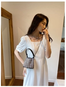 Female model wearing a mini sparkling rhinestone bucket bag with chain strap
