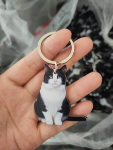 Detail of double-sided acrylic tuxedo cat keychain with durable silver metal ring
