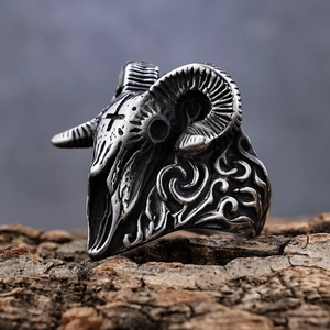 Macro shot of punk style ram skull ring with cross engraving on textured wood base