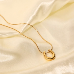 18K gold plated U-shape pendant necklace with snake chain on champagne silk