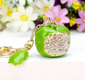 Detailed macro view of green enamel apple keychain with sparkling white rhinestones