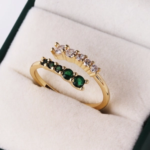 Macro view of adjustable gold ring with double rows of emerald and white zircon stones