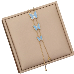 Golden snake chain necklace with three blue butterfly pendants on a display pad