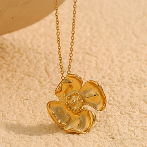 Macro shot of an 18K gold plated 316L stainless steel vintage flower pendant necklace