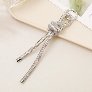 Detail of silver knot keychain with sparkling rhinestones and metal ring holder