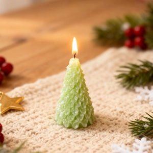 Groene kerstboom geurkaars met dennennaald textuur op een gezellige gebreide deken