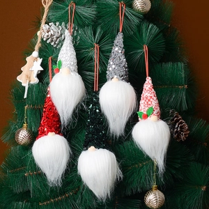 Set mit Weihnachts-Wichteln und Paillettenmützen am grünen Weihnachtsbaum aufgehängt