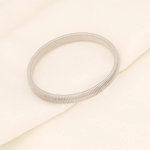 Detailed view of silver elastic metal bracelet showing flexible wire texture on silk background