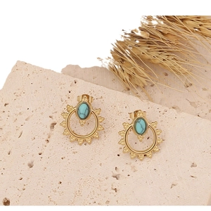 Bohemian gold stud earrings with oval turquoise inlay on a textured beige stone base