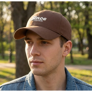 Close-up of white 3D embroidery 'Since FASHION' on a brown cotton baseball cap