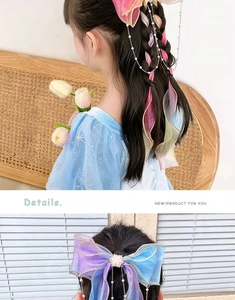 Detail of colorful gradient tulle hair bow with pearl tassels and gold stitching