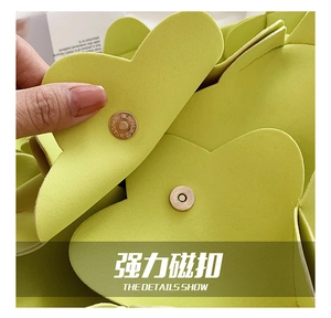 Macro view of the secure magnetic metal clasp closure on the yellow flower petal bag