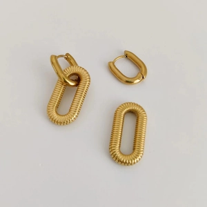 Detailed view of gold-plated U-shaped earrings with textured oval link pendants