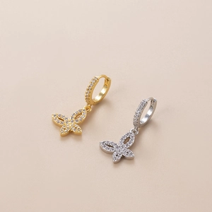 Detailed view of butterfly zircon earrings in gold and silver finish with crystal stones