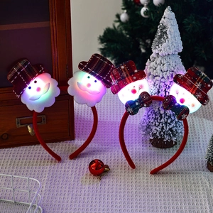 Close-up of four LED glowing Christmas headbands with plush Santa and snowman characters