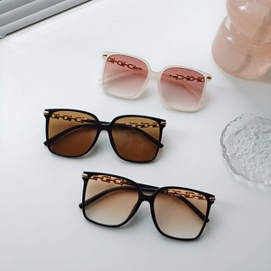 Fashionable oversized sunglasses with gold chain detail in pink and brown gradient lenses