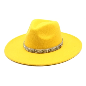 Detail of yellow wool fedora hat featuring a sparkling rhinestone band and golden M logo