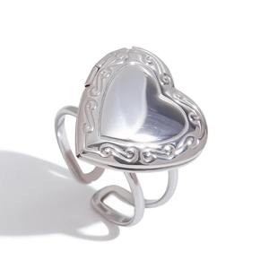 Dettaglio anello locket a cuore argento con motivi a rilievo e superficie lucida