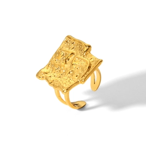 Macro detail of golden hammered texture on irregular geometric stainless steel ring