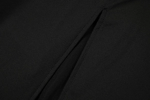 Macro detail of high-quality black fabric stitching and side slit on this slim dress