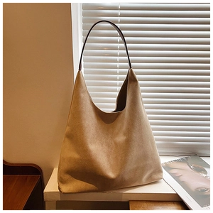 Detail of camel suede tote bag showing soft matte texture and deep brown shoulder strap