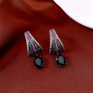Detail of vintage oval black gemstone earrings on dark brown silk fabric with zircon