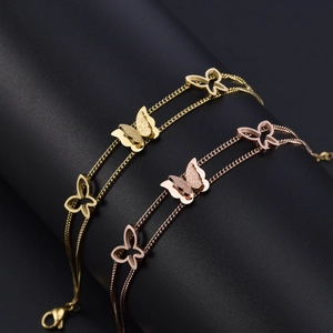 Zweilagiges Schmetterlingsarmband in Gold und Roségold auf einem Schmuckständer
