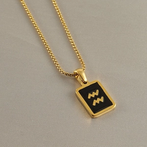 Detail of a square black Aquarius pendant with gold relief on a stainless steel chain