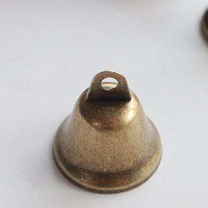 Detailed view of 3.8cm antique bronze trumpet bell with vintage texture and top hanging loop