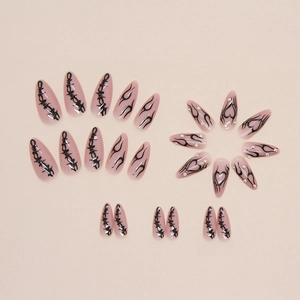 Long almond press-on nails with black gothic graffiti patterns and sparkling rhinestones
