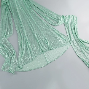 Detailed close-up of mint green sequins on a fishtail dress with high-density reflection